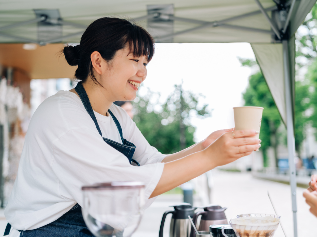 コーヒーを手渡すMutsumi