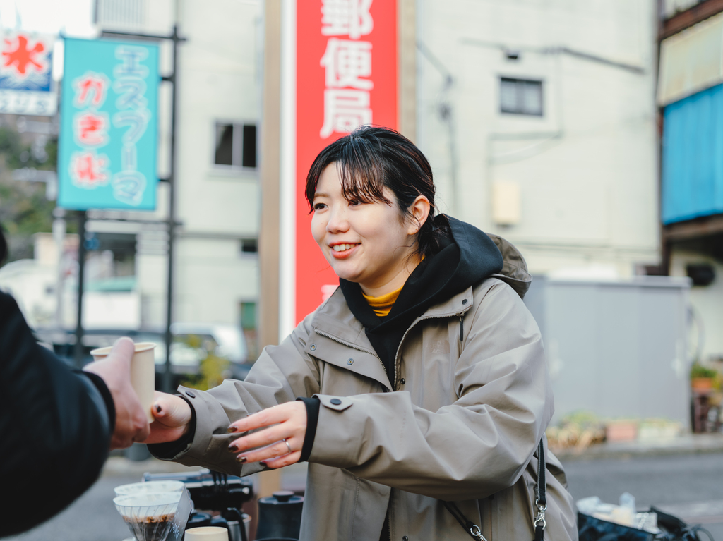 コーヒーを手渡すMutsumi